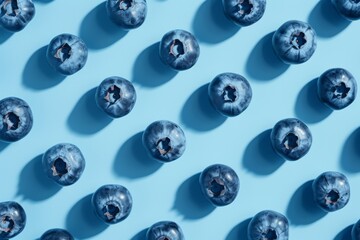 A vibrant display of nature's sweetness as a cluster of ripe blueberries rests upon a serene blue canvas, beckoning with their luscious hue and irresistible taste