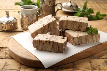 Tasty chocolate halva with mint on wooden table, closeup