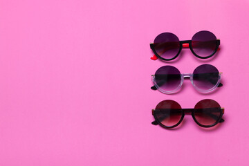 luxury fashionable sunglasses on pink and purple background, flatlay top view