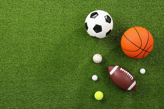 Many different sports balls on green grass, flat lay. Space for text © New Africa