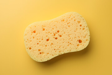 New sponge on yellow background, top view
