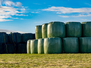 Stroh und Silage Ballen lagern auf einem Feld im Winter