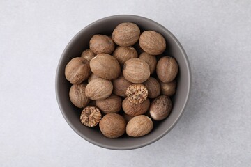 Nutmegs in bowl on light table, top view