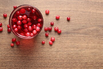 Tasty cranberry juice in glass and fresh berries on wooden table, top view. Space for text