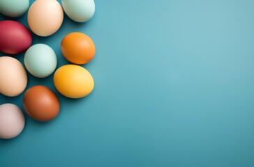  a group of colorful eggs sitting on top of a blue surface with an orange one in the middle of the group and a yellow one in the middle of the group.