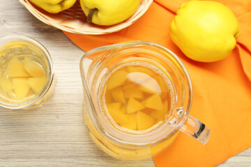 Delicious quince drink and fresh fruits on wooden table, top view