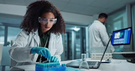 Scientist, woman and typing on laptop with test tube for chemistry, research or experiment at lab. Science, computer and serious medical professional in development of cure, biotechnology or study