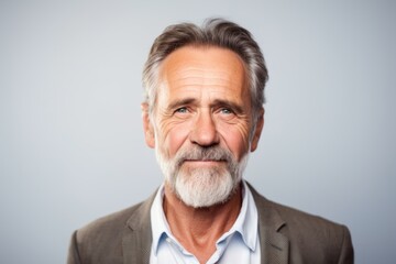 Portrait of senior man with grey hair and beard. Isolated on grey background.