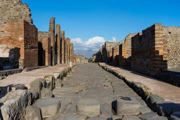 roman road with worn stones by the passage of horse carts in the archeological park of...