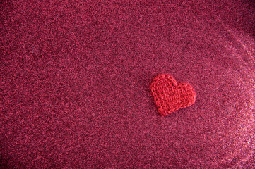 Red or maroon glistening background. Sunlines pattern. Crocheted elements. One red hearts.
