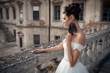 Naklejka premium elegant bride fashion model posing at ancient castle in luxury wedding dress