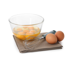 Whisk, raw eggs and bowl with yolks isolated on white