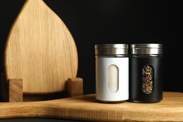 Salt and pepper shakers on table against black background