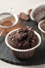 Delicious chocolate muffins on light table, closeup