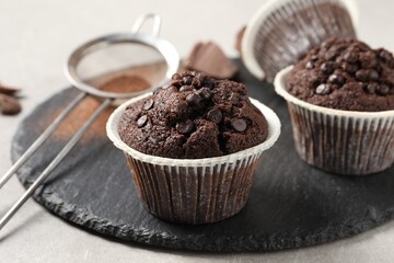 Delicious chocolate muffins on light table, closeup