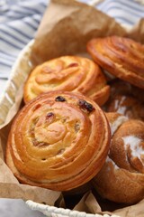 Delicious rolls with raisins and sugar powder on table, closeup. Sweet buns