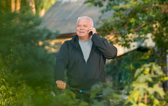 elderly man on vacation on a walk with a smartphone - Powered by Adobe