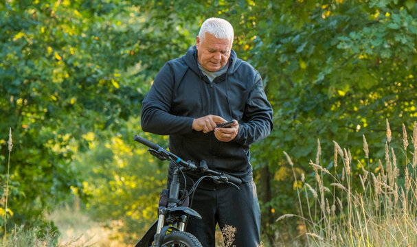 elderly man on vacation on a walk with a smartphone - Powered by Adobe