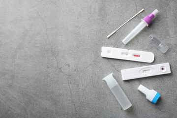 Disposable express test kits on grey table, flat lay. Space for text