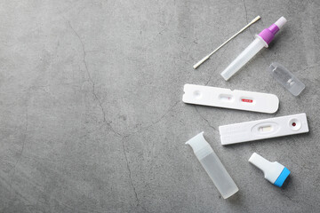 Disposable express test kits on grey table, flat lay. Space for text
