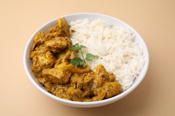 Delicious chicken curry with rice on beige background, closeup