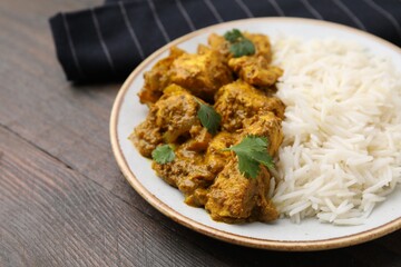 Delicious chicken curry with rice on wooden table, closeup