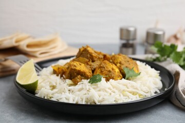 Delicious chicken curry with rice on grey table, closeup