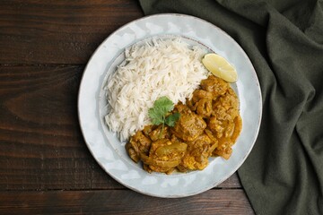 Delicious chicken curry with rice on wooden table, top view