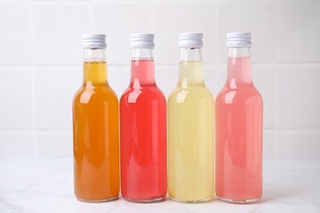 Delicious kombucha in glass bottles on white marble table