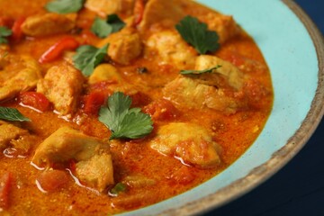 Delicious chicken curry with parsley on table, closeup
