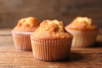 Delicious sweet muffins on wooden table, closeup