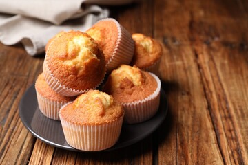 Delicious sweet muffins on wooden table, closeup. Space for text