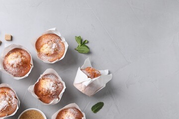 Delicious muffins on grey table, flat lay. Space for text