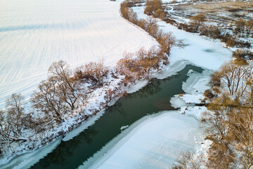 View of a freezing river at the beginning of winter, ice formation on the river from the air