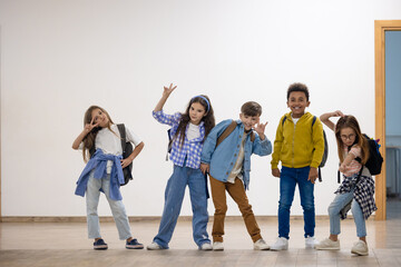 Group of elementary school kids standing in school corridor.