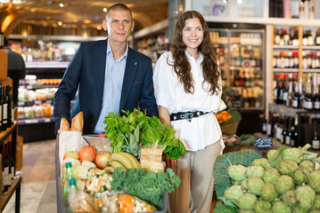 Portrait of a happy young man and girl in a supermarket, who came to shop