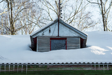 Dormer window in the attic of an old house with a television antenna, the roof covered with white...