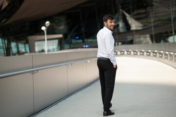 Young tall man in white shirt walking and smiling