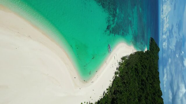 Captivating aerial footage  of the Puka beach, a tropical sandy beach nestled on the north coast of Boracay island, Philippines. Vertical video orientation.