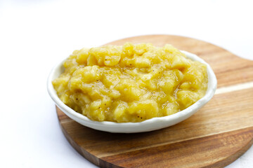 Mashed banana in bowl on white background.
