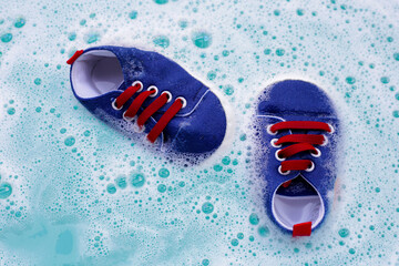 Soak baby shoes in baby laundry detergent water dissolution before washing. Laundry concept, Top...