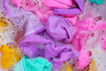 Dirty socks soaked in water, dissolving detergent in basin.