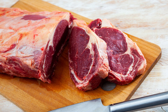 Pieces of raw boneless tenderloin beef on wooden background prepared for roasting