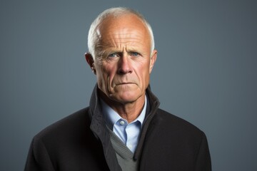 Senior man with a serious expression on his face over grey background.