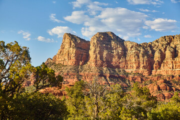Sedona Red Rock Formations with Lush Greenery and Cloudy Skies