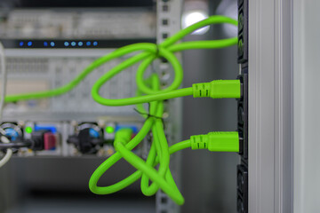 Green IEC 60320 C14 power cables plugged into IEC 60320 C13 sockets in the server cabinet.