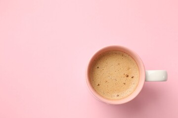 Aromatic coffee in cup on pink background, top view. Space for text