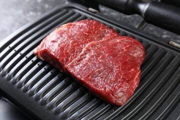 Cooking fresh beef cut on electric grill, closeup
