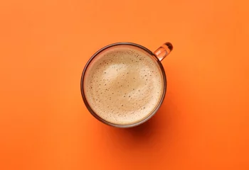 Foto op Plexiglas Fresh coffee in cup on orange background, top view © New Africa