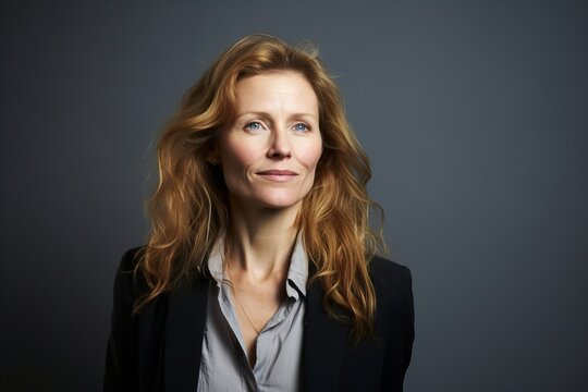 Portrait Of A Senior Business Woman With Long Red Hair. Studio Shot.